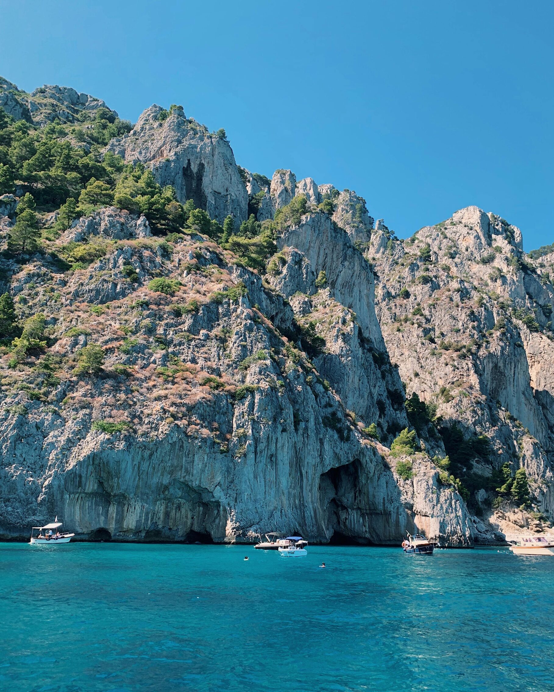 Breathtaking view of hills and clear blue waters in Capri, perfect for summer travel.