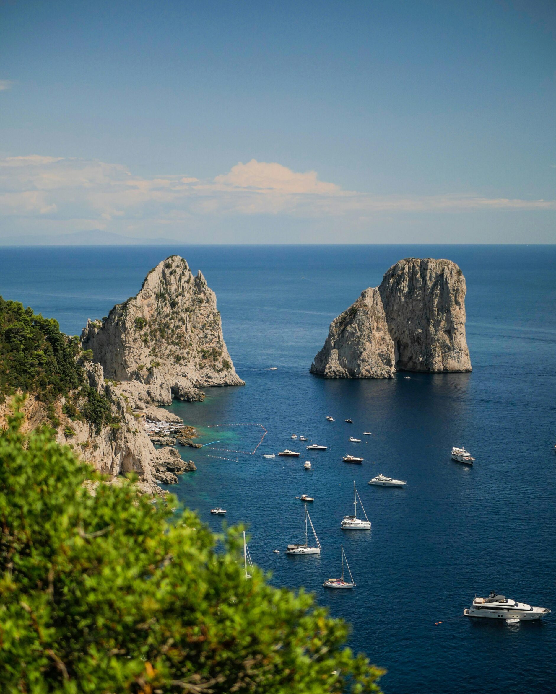A breathtaking aerial view of the Faraglioni rock formations with yachts in Capri, Italy.